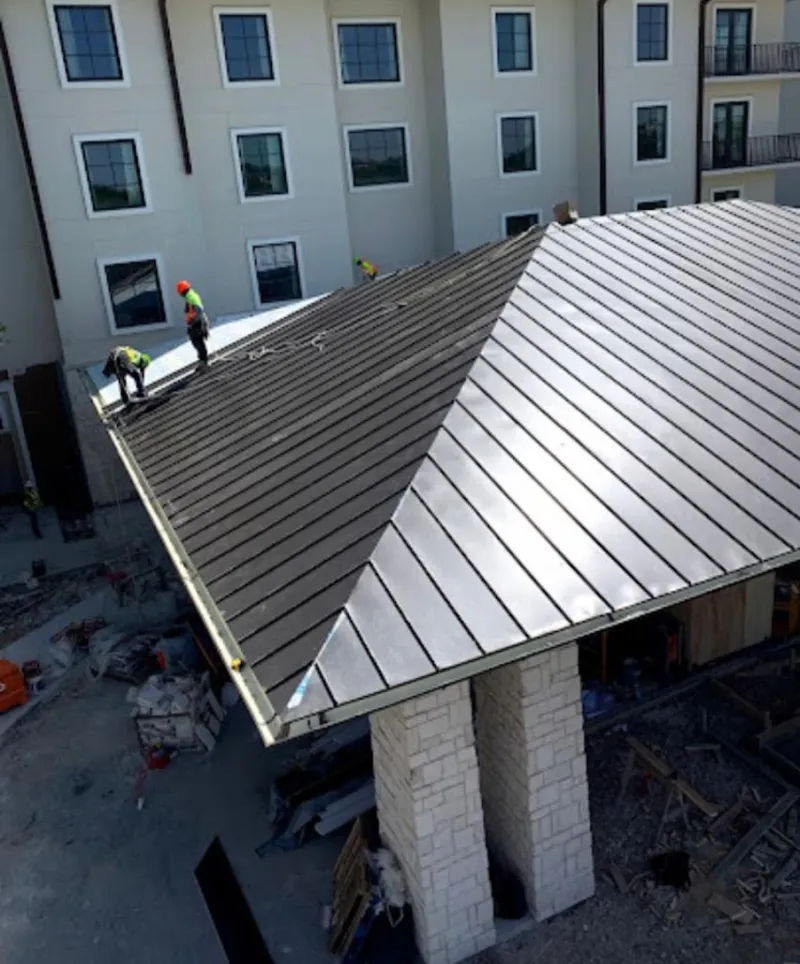 Crew installing standing seam metal roof panels on a commercial project in Wilkes-Barre